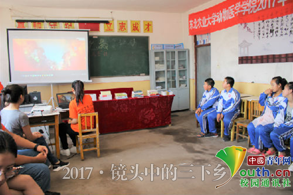 图为实践队员为留守儿童播放宣传片。中国青年网通讯员 夏婷婷 摄